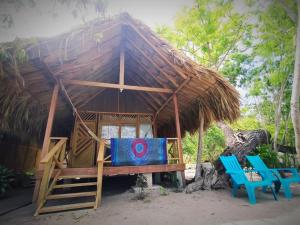 格兰德岛Centro Ubuntu的小小屋设有2把蓝色椅子和茅草屋顶