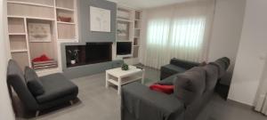 滨海托萨Apartamento Martin的客厅配有沙发、椅子和电视
