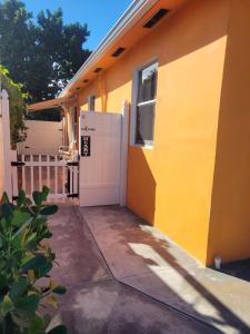 迈阿密Welcome Heart and Reliable Heart Vacation Houses的黄色的房子,设有车库和窗户