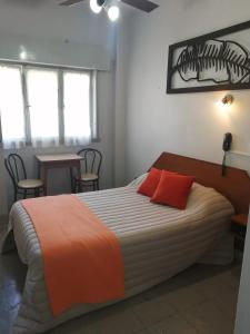 布宜诺斯艾利斯Suite Confortable en Palermo Omega的一间卧室配有一张大床和两个红色枕头