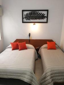 布宜诺斯艾利斯Suite Confortable en Palermo Omega的两张带橙色枕头的床