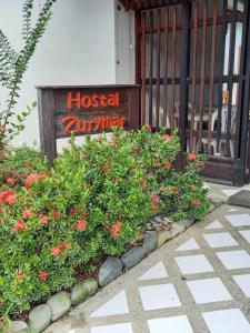 卡普兰干Hostal Zurymar Capurganá的建筑前鲜花盛开的酒店标志