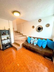 墨西哥城DEPTO FRENTE AL AUTODROMO HMNOS A 10 MIN CAMINANDO的客厅配有带蓝色枕头的棕色沙发