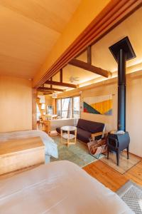 神户ROKKONOMAD的一间卧室设有两张床和一个壁炉