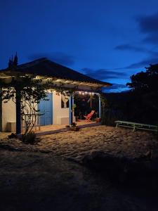 莱瓦镇El Oteo Tiny house.的一间有蓝色门的房子,晚上有长凳