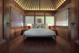 塞米亚克The Legian Seminyak, Bali的一间设有床铺的卧室,位于带窗户的房间内