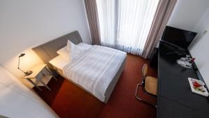 波恩Wissenschaftszentrum Bonn的酒店客房,配有床和电视