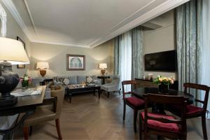 罗马Rocco Forte Hotel De La Ville的客厅配有沙发和桌子