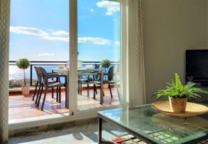 贝纳尔马德纳Brisa Quebrada Beach, 2 Bed, Sea Views, Pool的一间带玻璃桌的客厅和一个阳台
