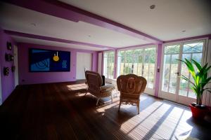 圣日耳曼昂莱Villa Talisman的紫色的房间,配有两把椅子和一棵植物