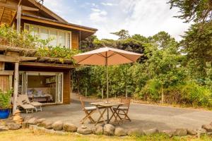 奥波诺尼Hokianga Haven的屋前带雨伞的桌子