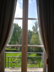 奥登河畔的布雷特维尔Chambres d'Hôtes Le Bas Manoir的开放式窗户,享有花园的景色