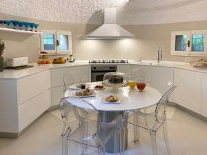 特雷梅佐Villa Lina的白色的厨房配有桌椅