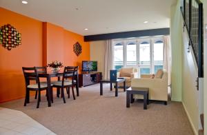惠灵顿威利斯村酒店的客厅设有橙色墙壁和桌椅