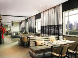 新加坡Rendezvous Hotel Singapore by Far East Hospitality的餐厅设有桌椅和窗户。
