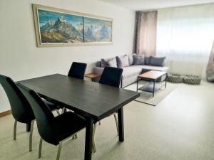 格林德尔瓦尔德Nika Apartment - Aare Jungfrau AG的客厅配有桌椅和沙发