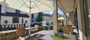 帕德博恩Hotel Aspethera的一个带桌子和遮阳伞的庭院