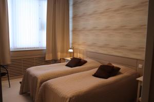 库萨莫Ruva Holidays的配有大窗户的酒店客房内的两张床