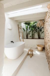 圣埃乌拉利亚坎多摩农场酒店的一间带白色浴缸和椅子的浴室