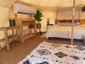 KaliaGlamping -420的蒙古包内一间卧室,配有一张床和地毯