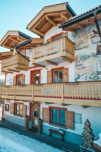 维哥迪法萨Casa di Franz的一座带木制阳台的建筑,上面有壁画