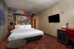 阿姆斯特丹Inntel Hotels Amsterdam Landmark的酒店客房设有一张大床和一张书桌。