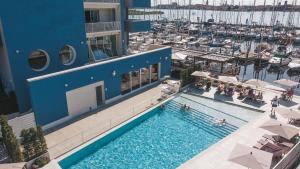 索托马里纳Mosella Suite Hotel的享有带码头的大楼游泳池的顶部景致