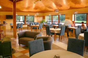 尤卡尔内雷达格斯旅馆的一间设有桌椅的餐厅,有坐在桌子上的人