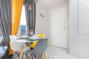 格但斯克Platinum Tartaczna Apartments by Renters的一间带桌子和黄色椅子的用餐室