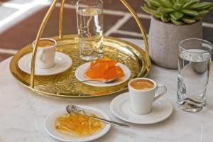 法里拉基Amada Colossos Resort的一张桌子,上面放着两杯咖啡和一盘食物