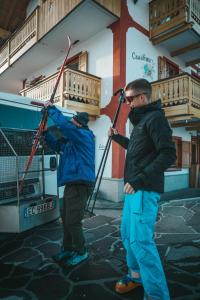 维哥迪法萨Casa di Franz的两名有滑雪设备的人站在大楼外