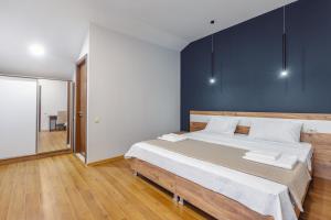 博尔若米10 KEYS Boutique Hotel的一间卧室设有一张大床和蓝色的墙壁