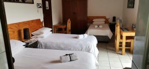 伊丽莎白港The Bay Inn的酒店客房设有三张床和一张书桌