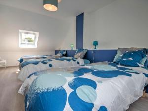 HerbignacGîte Herbignac, 4 pièces, 7 personnes - FR-1-306-1105的一间卧室配有两张带蓝白色床单的床