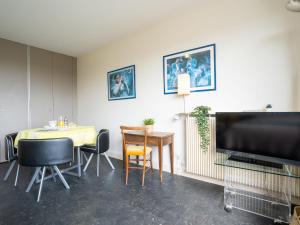比亚里茨Apartment Château d'Arcadie-1 by Interhome的用餐室配有桌椅和平面电视。