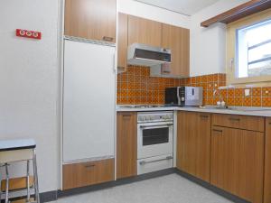 采尔马特Apartment Richemont by Interhome的厨房配有木制橱柜和白色冰箱。