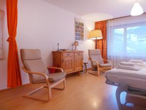 采尔马特Apartment Richemont by Interhome的一间卧室配有两把椅子、一张床和一个梳妆台