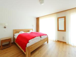 采尔马特Apartment Zur Matte B-2 by Interhome的一间卧室配有一张带红色毯子的木床