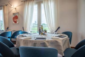 福洛尼卡Riva Toscana Golf Resort & SPA的一间带桌子和蓝色椅子的用餐室
