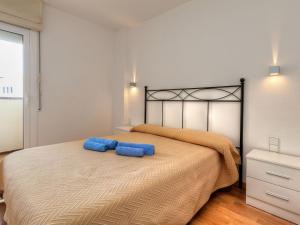 莱斯卡拉Apartment Port L'escala-1 by Interhome的一间卧室配有一张大床和蓝色枕头