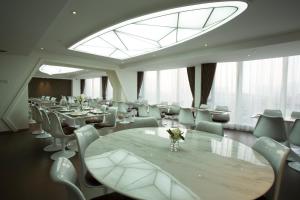 广州广州普兰内特概念酒店的一间带桌椅的用餐室和大窗户