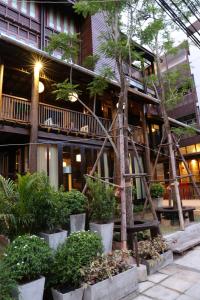 清迈Kampaeng Ngam Hotel - SHA Extra Plus的前面有树木和植物的建筑