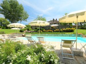拉波拉诺泰尔梅Apartment San Biagio by Interhome的游泳池旁的游泳池配有椅子和遮阳伞