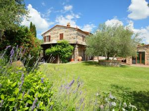 拉迪科法尼Holiday Home Val d'Orcia by Interhome的一座大型石头房子,前面设有一个花园