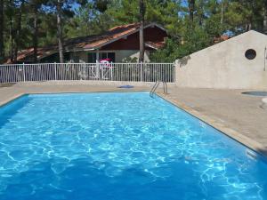 拉卡诺奥肯Holiday Home Golf Loisirs-4 by Interhome的一座大蓝色游泳池,位于房子前