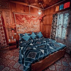 斯利那加Lake Palace Group Of House Boats的卧室配有一张床铺,位于带木墙的房间内