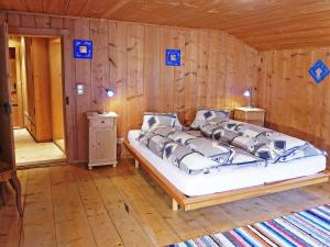 米施泰尔Holiday Home Ferienhaus Döss by Interhome的木制客房内的一间卧室,配有一张床