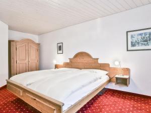格林德尔瓦尔德Apartment Chalet Abendrot-29 by Interhome的一间卧室配有一张大床和木制床头板