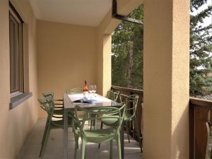圣莫里茨切萨浪漫公寓的阳台的用餐室配有桌椅