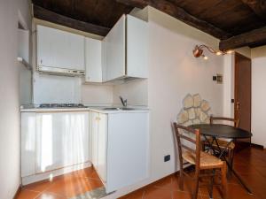 奥尔塔圣朱利奥Apartment Mansarda by Interhome的厨房配有白色橱柜和桌椅